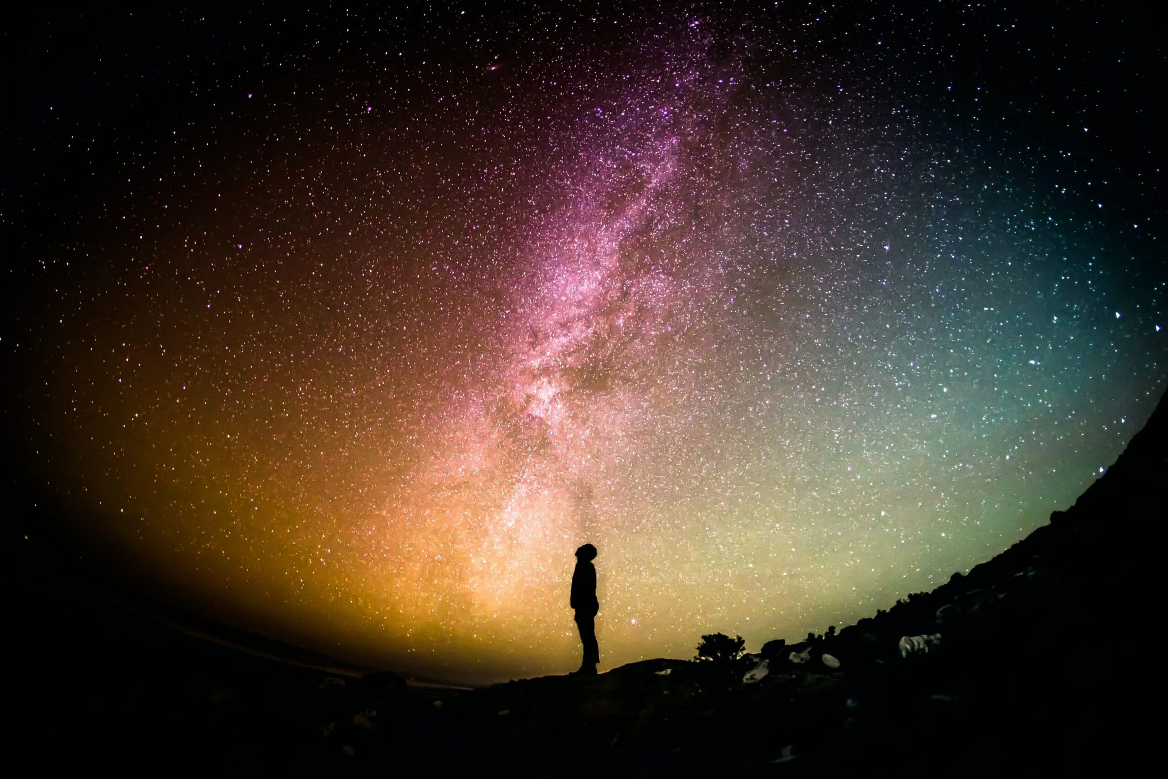A person silhouetted under the Milky Way at night