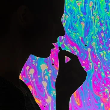 Silhouette of a person in profile against swirling, brightly coloured patterns
