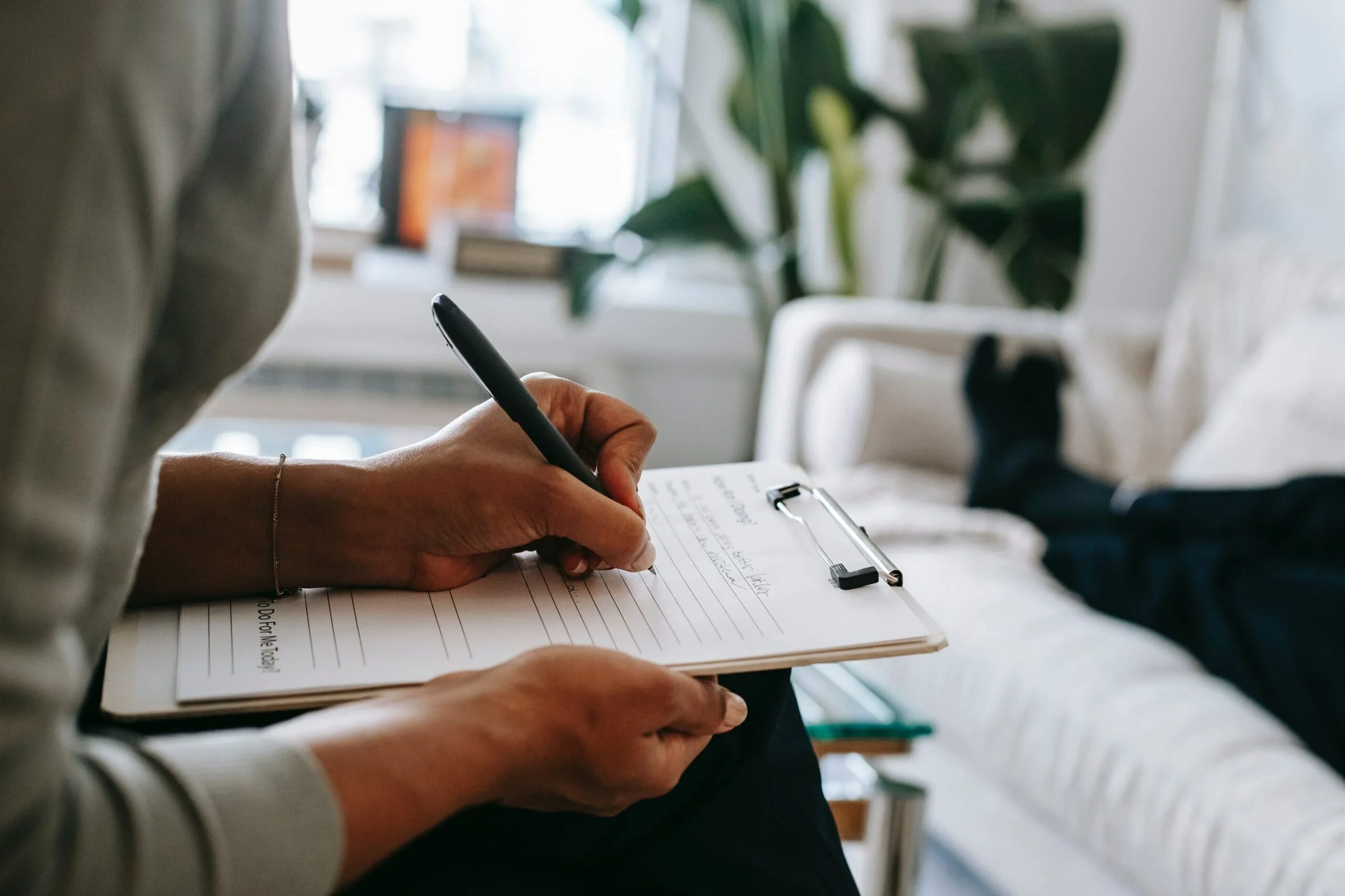 A person filling in a paper questionnaire on a clipboard